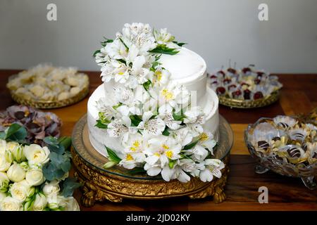 magnifique gâteau de mariage blanc en deux couches décoré de fleurs d'astromélie Banque D'Images