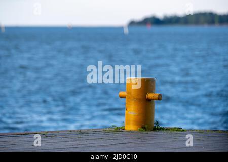 Helsinki / Finlande - 15 JUIN 2022 : gros plan d'un bollard amarré contre une mer bleu vif. Une petite île à l'horizon. Banque D'Images