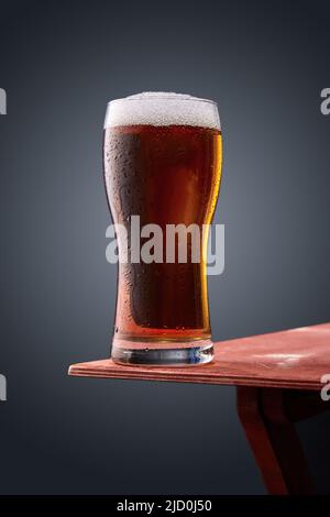 Un verre de bière se trouve sur le bord de la table Banque D'Images