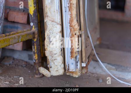 Mousse de montage de construction sur les fenêtres en plastique démontées en gros plan. Remplacement de fenêtres obsolètes Banque D'Images