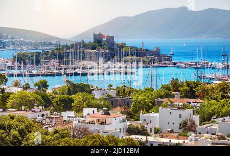 Vue sur le château de Bodrum et le port de plaisance en mer Égée avec des bateaux à voile et des collines en arrière-plan en Turquie Banque D'Images