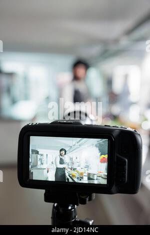 Gros plan de l'appareil photo film gastronomie expert cuisine plat de légumes pour cours en ligne d'école culinaire. Chef cuisinier cuisant des aliments savoureux tout en vlogging processus dans la cuisine professionnelle de restaurant. Banque D'Images