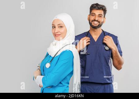 professionnel musulman médecin femme et assistant indien discuter des tâches. portrait de beaux travailleurs médicaux avec des stéthoscopes. Aide médicale, assurance Banque D'Images