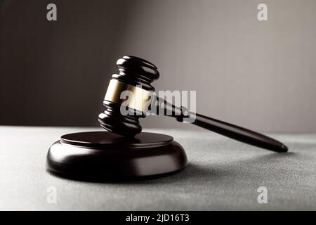 Thème droit, maillet du juge sur un bureau en bois avec statue de Lady Justice. Faire droit sur un fond sombre et brumeux avec de la lumière. Banque D'Images