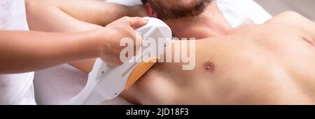 Close-up of Smiling Young Man Having Underarm Traitement d'enlèvement de cheveux de laser à Spa Banque D'Images