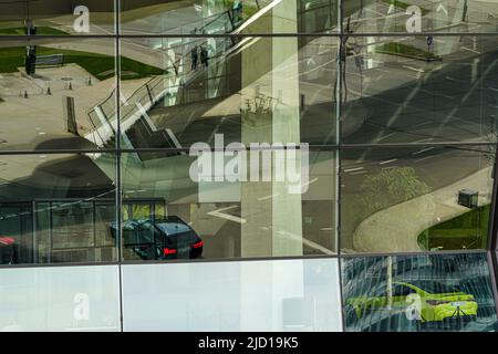 Réflexions du pont DE TRIAS et des environs dans la façade de verre de BMW World Munich, Allemagne, 22.4.22 Banque D'Images