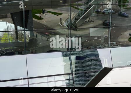 Réflexions de la tour BMW et des environs dans la façade de verre de BMW World Munich, Allemagne, 19.4.22 Banque D'Images