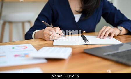 Femme comptable ou consultante en finances travaillant avec son rapport de vente comptable, analysant les données financières à son bureau. Banque D'Images
