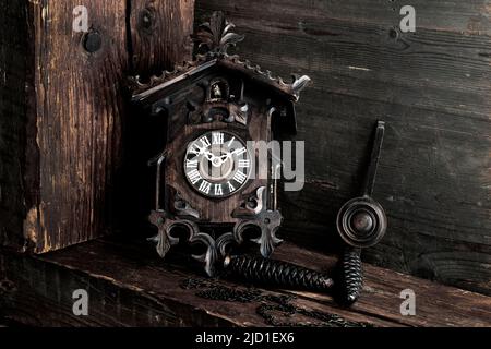 Horloge à coucou de la Forêt Noire antique sur fond de bois, prise de vue en studio, Forêt Noire, Bade-Wurtemberg, Allemagne Banque D'Images