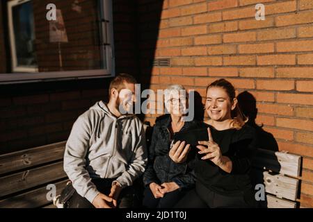 Grand-mère avec petits-enfants adultes prenant le selfie Banque D'Images