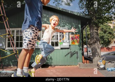 Enfants amis jouant dans l'aire de jeux Banque D'Images