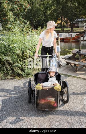 Mère à vélo avec enfant en voiture Banque D'Images