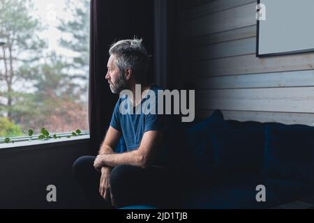Triste homme assis sur un canapé Banque D'Images