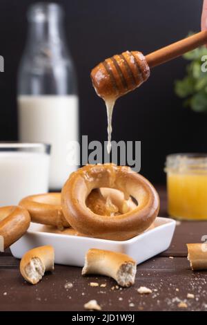 Des petits pains russes traditionnels avec du lait et du miel sur une table en bois. Dessert de farine populaire Banque D'Images