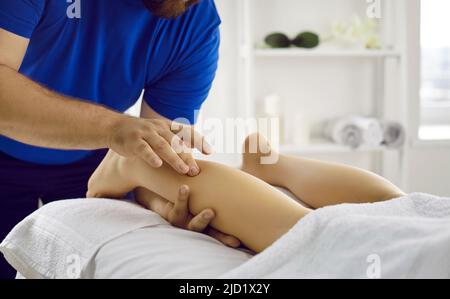 Masseur professionnel, physiothérapeute, ostéopathe ou chiropraticien faisant des massages de jambes Banque D'Images