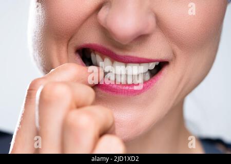 Close-up of a woman Biting son ongle Banque D'Images