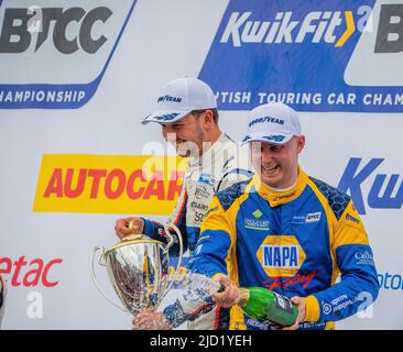 Ashley Sutton et Tom Ingram sur le podium à Oulton Park, avec Ash Sutton pulvérisant du champagne sur la foule, bataille de Tom et Ash Banque D'Images