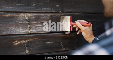 rénovation de parements en bois extérieurs de la maison. peinture de restauration de l'homme de vieilles planches en bois Banque D'Images