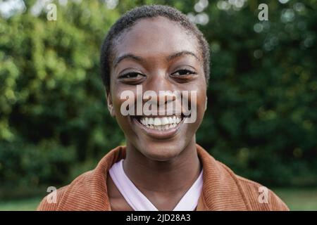 Bonne fille blanche africaine souriante sur la caméra - Focus sur le visage Banque D'Images