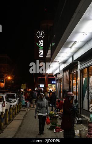 Un homme est vu passer devant un auguiste qui vend des fruits et des légumes à l'extérieur d'une succursale du supermarché Naivas, l'une des plus grandes chaînes de vente au détail 24 heures du Kenya dans le quartier des affaires de Nakuru. Le coût de la vie a augmenté de façon astronomique en raison d'une augmentation du coût mondial du pétrole brut avec un taux d'inflation de 7,1% comme enregistré au mois de mai 2022, un plus haut de 27 mois par rapport à février 2020, 7,2%. Le coût de la plupart des biens de consommation a plus que doublé, ce qui met une pression sur un échantillon représentatif de Kenyans. Banque D'Images