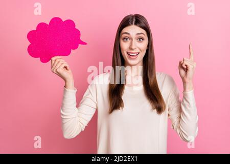 Portrait d'une fille gaie et attrayante tenue copie carte d'espace annonce point vers le haut isolé sur fond rose pastel couleur Banque D'Images