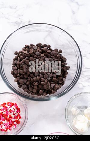 Ingrédients mesurés dans un bol à mélanger en verre pour préparer des fraises enrobées de chocolat. Banque D'Images