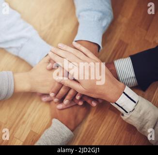 Les mains vers le bas, la meilleure équipe à avoir sur le projet. Photo rognée d'un groupe de gens d'affaires qui se réunissent les mains dans l'unité. Banque D'Images