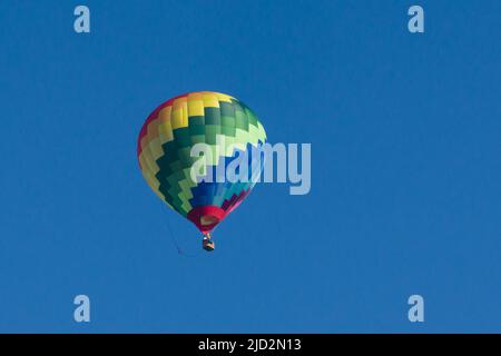 Ballon à air chaud Lindstrand LTL série 1-105 coloré dans un ciel bleu clair Banque D'Images