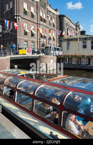 Amsterdam, Hollande : touristes sur un bateau avant de partir pour une visite touristique dans les canaux d'Amsterdam. Banque D'Images