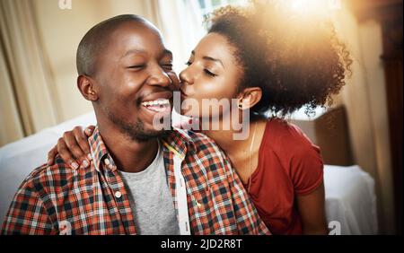 Montrer un peu d'amour. Photo courte d'un jeune couple affectueux qui profite de la journée à la maison. Banque D'Images