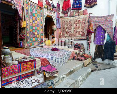 Pushkar, Rajasthan Inde - 4 novembre 2019 : marché local de rue vendant des tapis, des tapis, des vêtements accrochés à l'extérieur de la boutique Banque D'Images