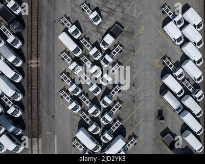 Vue aérienne de nouveaux camions alignés dans le port pour l'importation et l'exportation logistique d'affaires à la concession pour la vente, automobile et parking de camions automobiles. Banque D'Images