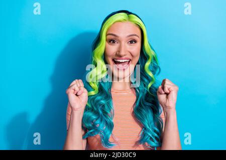 Portrait d'une jeune femme extravagante avec des cheveux teal ombre célébrer sa victoire à la loterie isolée sur fond bleu Banque D'Images