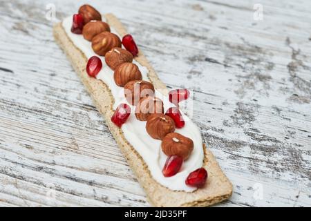 Pains croustillants au fromage à la crème et aux noix sur fond de bois blanc. Vue de dessus. Banque D'Images