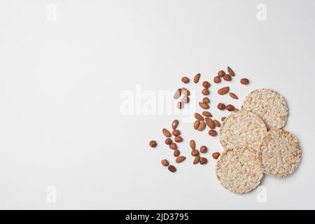 Pile de gâteaux de riz et de noix sur fond blanc. Des collations saines Banque D'Images