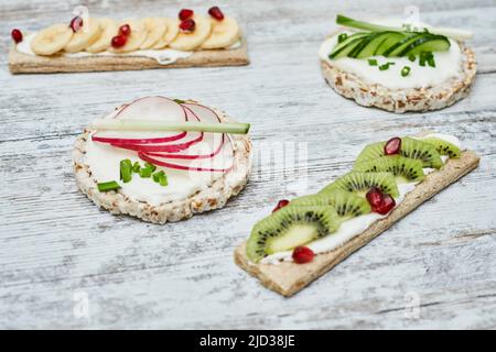 Gâteau au riz et pain grillé avec fromage à la crème et légumes sur bois Banque D'Images