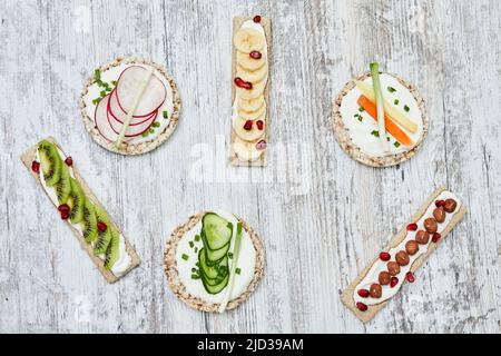 Gâteau au riz et pain grillé avec fromage à la crème et légumes sur bois Banque D'Images