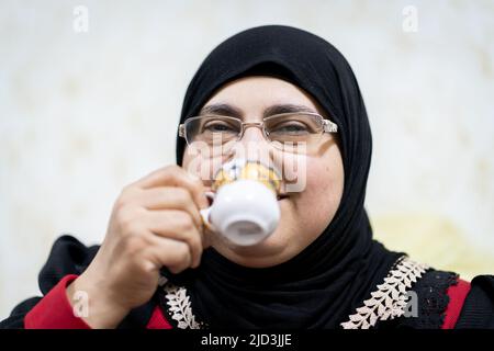 Portrait d'une femme musulmane d'âge moyen qui boit du café. Photo de haute qualité Banque D'Images