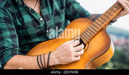 Les mains de l'homme jouant de la guitare acoustique, gros plan. Guitares acoustiques en train de jouer. Concept de musique. Guitares acoustiques. Musique live. Festival de musique. Musicien masculin Banque D'Images