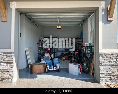 Orlando, FL États-Unis - 3 mars 2022: Un garage non organisé rempli de beaucoup de choses dans un quartier. Banque D'Images