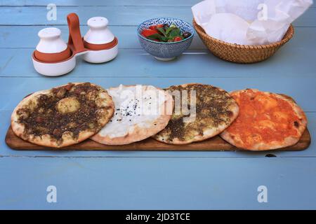 Un ensemble de maouajanet libanais ou de manaqish, de zaatar, de fromage et de lahm b ajin. Banque D'Images