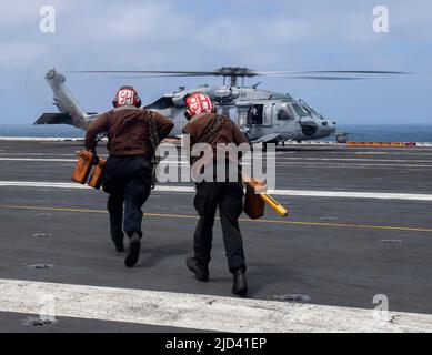 220614-N-YS933-1320 LES marins DE L'OCÉAN PACIFIQUE (14 juin 2022) se préparent à caler et à enchaîner un hélicoptère MH-60s Sea Hawk, provenant des « Indiens » de l'Escadron de combat de la mer (HSC) 6, à bord du porte-avions USS Nimitz (CVN 68). Nimitz est en cours dans la zone d'exploitation de la flotte américaine 3rd. (É.-U. Photo marine par Spécialiste des communications de masse 3rd classe Lorenzo Fekieta-Martinez) Banque D'Images