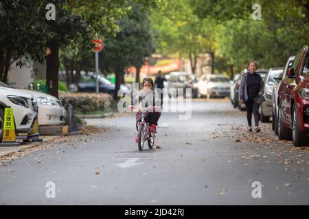 Une fille indonésienne et sa grand-mère vêtues d'un thème de printemps, un vélo BTWIN rose au printemps, dans la rue d'un complexe d'appartements à Shanghai Banque D'Images