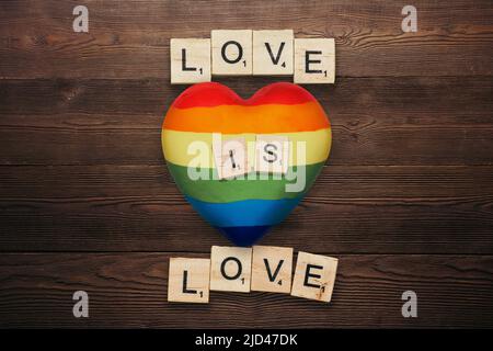 L'amour est l'amour. Photo de la gay Pride inspirée avec forme de coeur et lettrage de spectre arc-en-ciel. Le concept Homosexualité Emblem des droits LGBTQ+. Banque D'Images