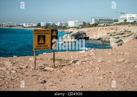 Signe de précaution sur le bord dangereux près des grottes de la mer à Ayia Napa, Chypre Banque D'Images