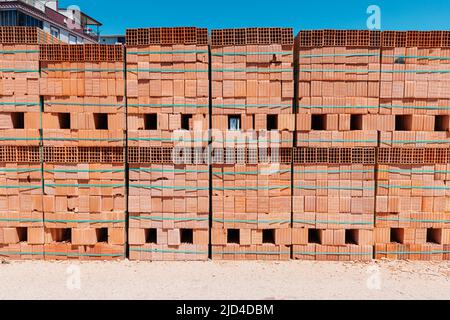 Palettes avec des racks de briques fraîchement préparés sur un chantier de construction ou près d'une usine industrielle. Stockage des matériaux de construction à l'entrepôt Banque D'Images