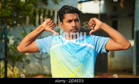 Jeune homme sportif pratiquant le yoga, faisant de l'exercice Sukhasana. Pantalon noir et chemise bleue, intérieur pleine longueur, studio de yoga Banque D'Images