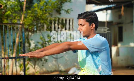 portrait de l'entraînement sportif de l'homme avec yoga à l'heure du matin. Effectue des exercices pour les muscles du dos et des mains. Concept d'entraînement à la maison en intérieur Banque D'Images