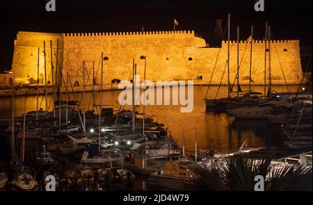 Forteresse d'Héraklion et port de pêche vénitien illuminés la nuit Banque D'Images