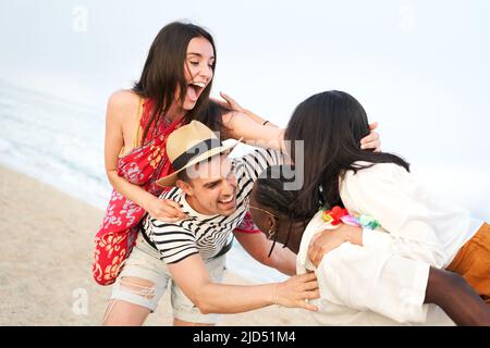 Amusez-vous avec vos amis. Groupe de jeunes joyeux jouant sur la plage en pigeyback Banque D'Images